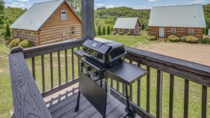 A wooden deck with a grill and a view of two cabins in a wooded area. - 2 Mi to Mabry Mill: Mtn-View Cabin w/ Porch! (Meadows of Dan)