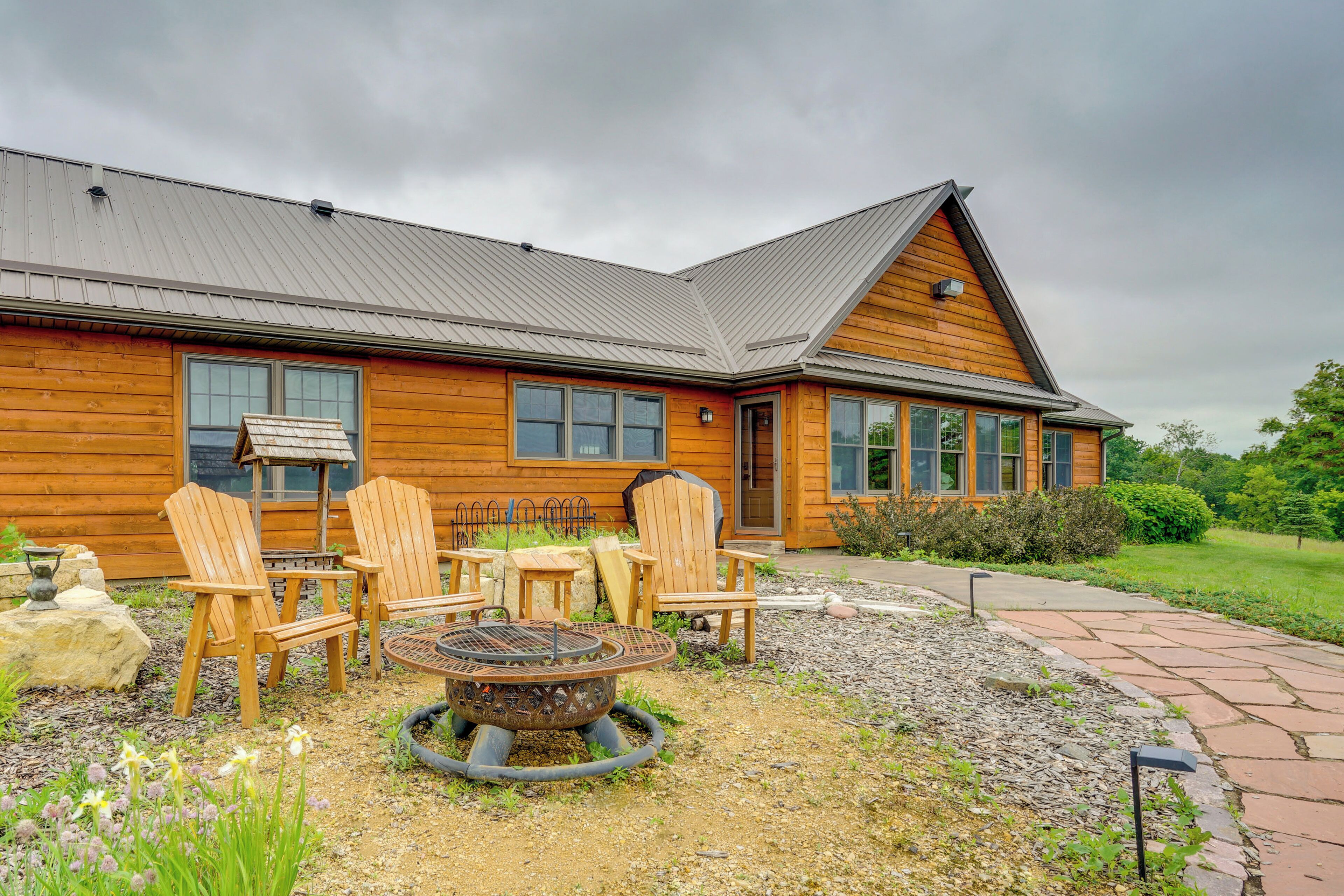 Un chalet en bois doté d’un foyer extérieur et de sièges pour se détendre en plein air.