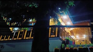 A two-story building with a balcony and potted plants. - Harsil apple homestay (Bhatwari)