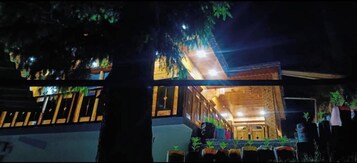 Ein zweistöckiges Gebäude mit Balkon und Blumentöpfen.