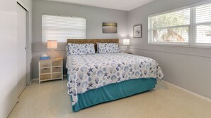 A bedroom with a bed, a nightstand, a ceiling fan, and a window with blinds. - 30-Day Retreat Near Siesta Key | Pet Friendly (Sarasota)