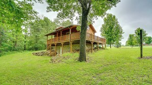 A wooden cabin with a balcony, surrounded by trees and grassy area. - On 30 Acres w/ Trails & Garden: Stockholm Cabin! (Stockholm)