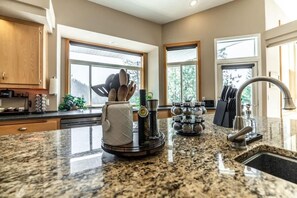 Eine moderne Küche mit Granit Arbeitsplatten, einer Kaffeemaschine, einem Wasserkocher und einem Messerblock.