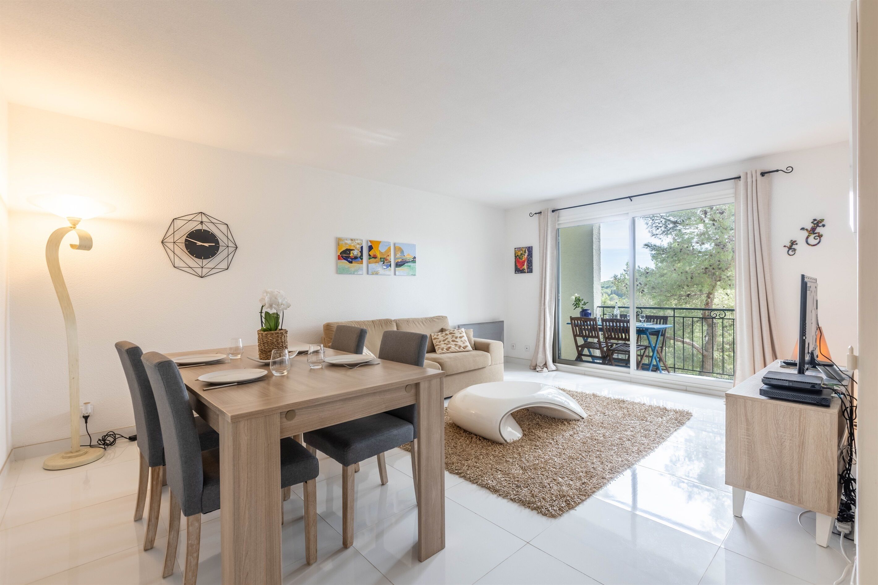 Ein modernes Wohnzimmer mit Esstisch, Sofa und großem Fenster mit Blick ins Freie.