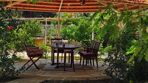 An outdoor patio with a tiled floor, a wooden table, and two chairs. - 4-bedroom Villa with Heating, Pool, Playgrounds, WiFi, Gardens: Douq, Batroun (محافظة الشمال)