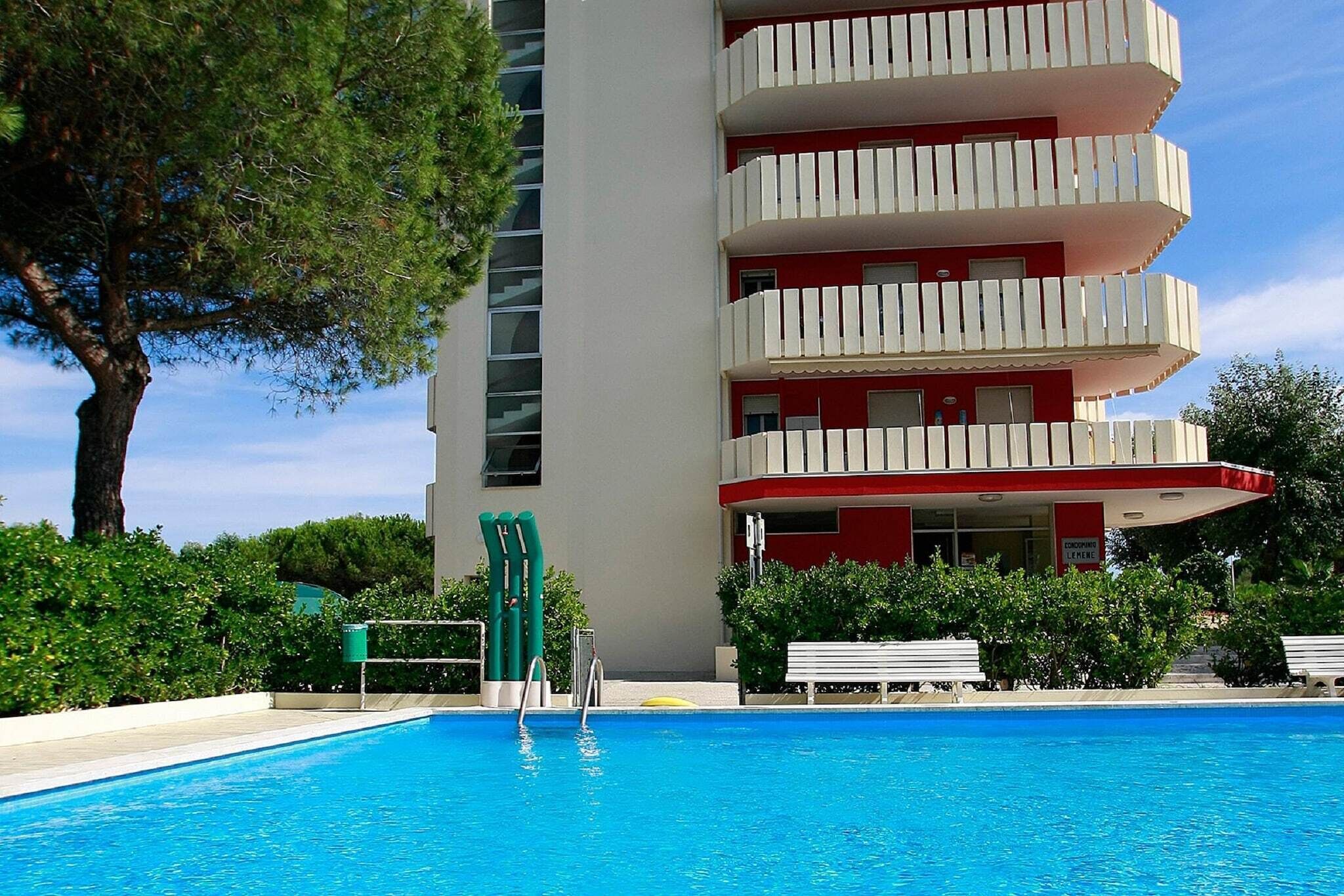 A swimming pool with a red and white building in the background.