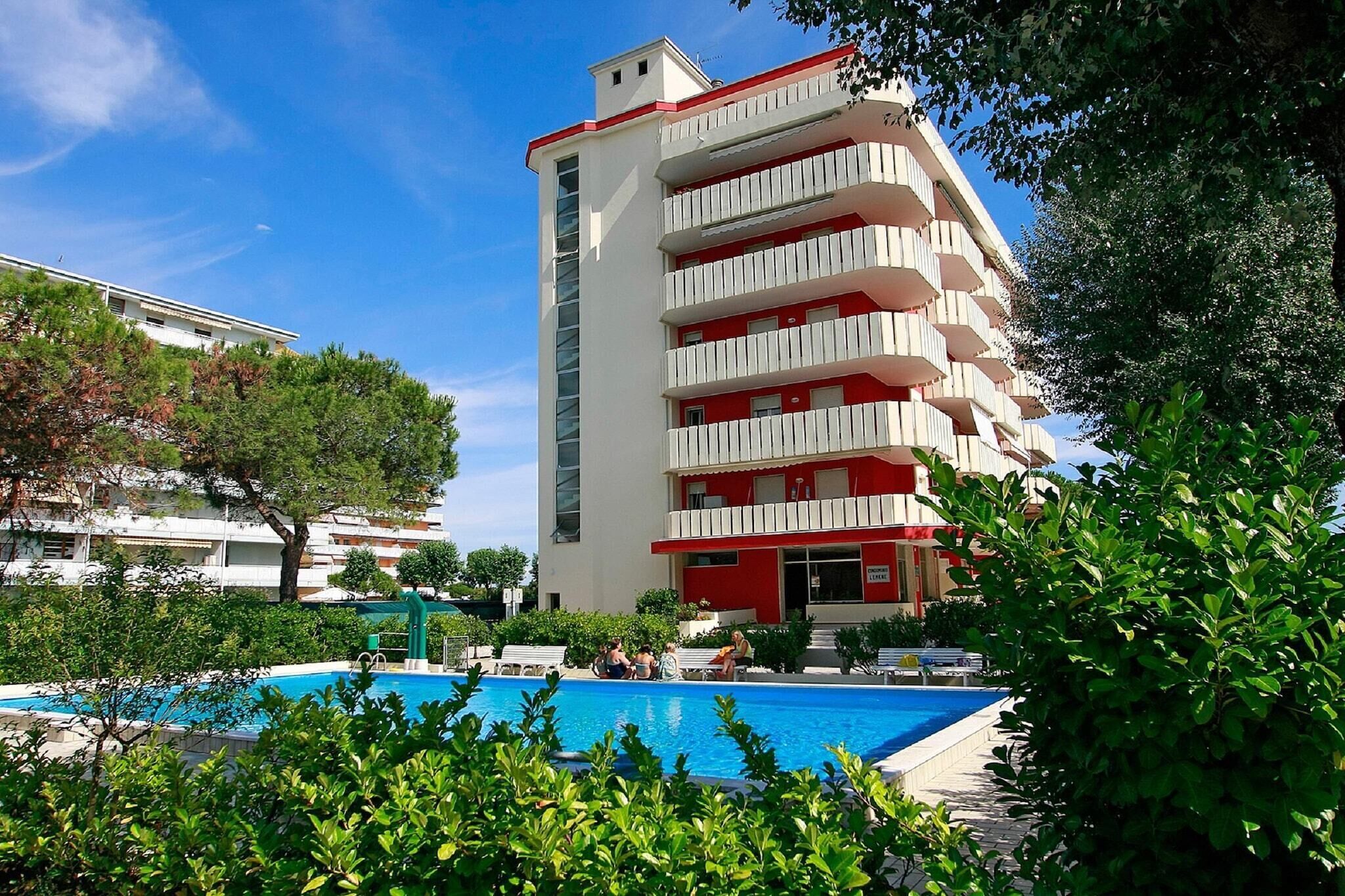 Un hotel a più piani con area piscina, immerso nel verde.