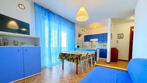 A compact living space with a dining area, kitchenette, and a bed. - Apartment a stone's throw from the beach (Porto Santa Margherita)