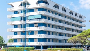 A multi-story hotel with balconies, a blue and white color scheme, and a clear sky. - Apartment a stone's throw from the beach (Porto Santa Margherita)