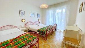A room with three beds, a desk, and a chair. - Apartment a stone's throw from the beach (Porto Santa Margherita)
