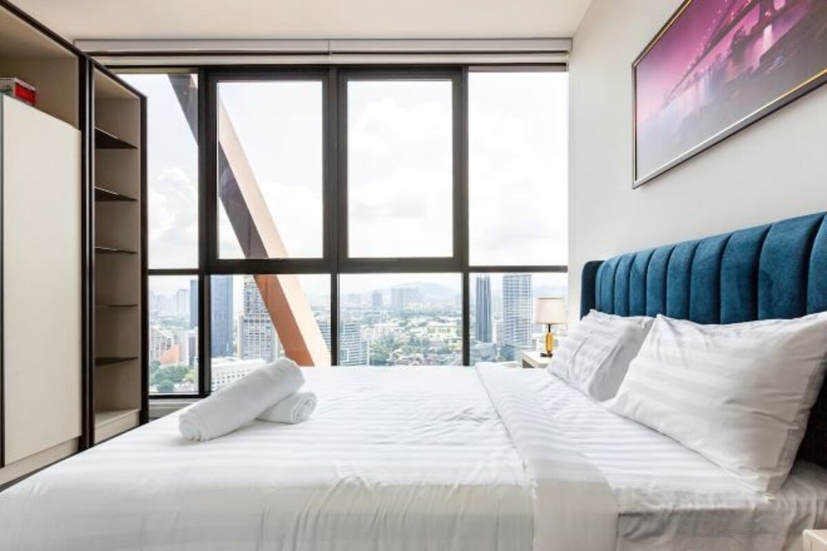 Een hotelkamer met een groot bed, uitzicht op de stad en een kledingkast.
