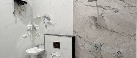 Un baño con inodoro, lavabo y ducha.