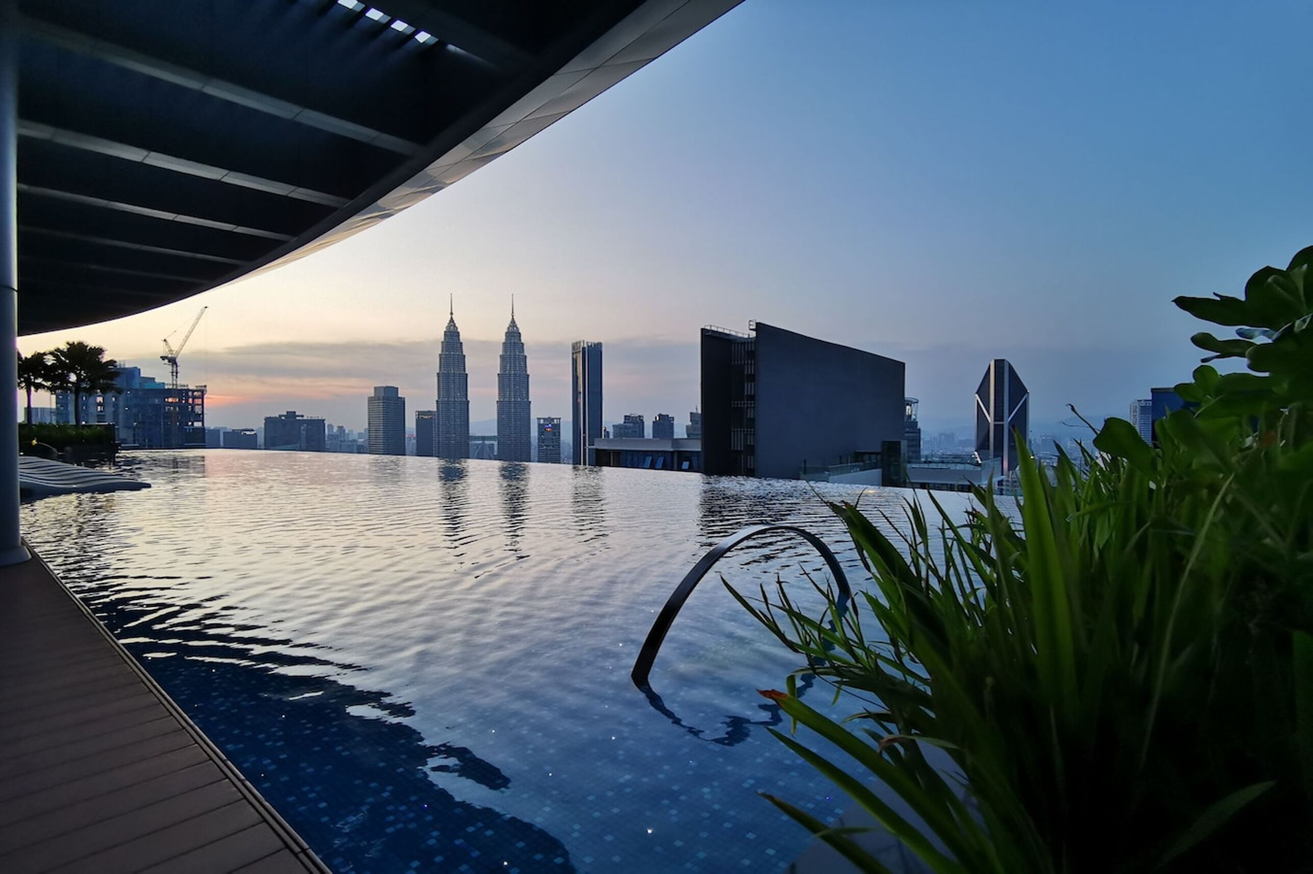 En infinitypool med stadens silhuett som bakgrund.