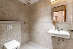 Un baño moderno con ducha, inodoro y lavabo.