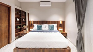 A modern bedroom with a large bed, wooden shelving, and a ceiling air conditioner. - The Monarch Stay by Red Olive (Bengaluru)