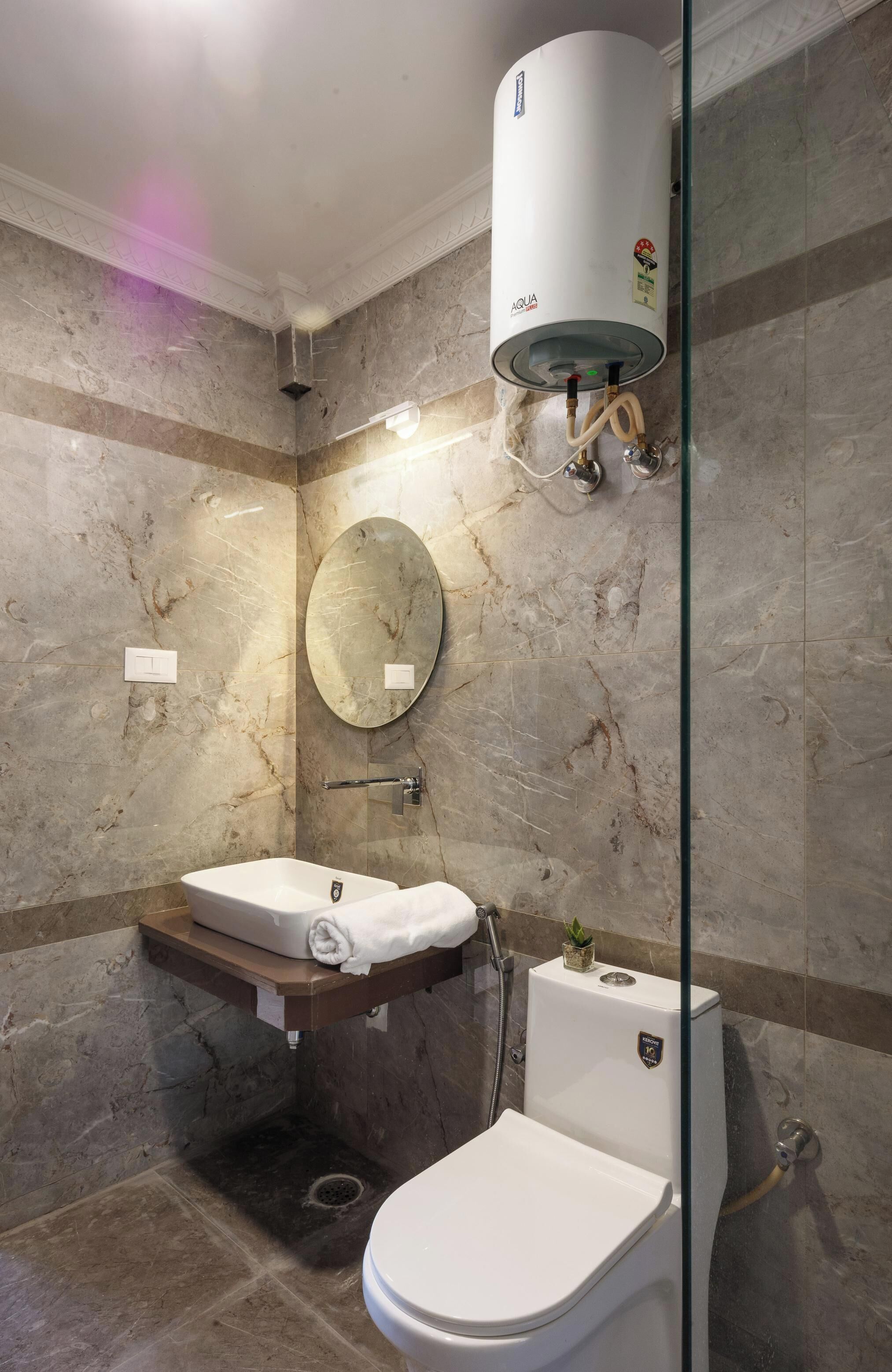 A modern bathroom with a built-in toilet, a vanity with a mirror, and a wall-mounted water heater.