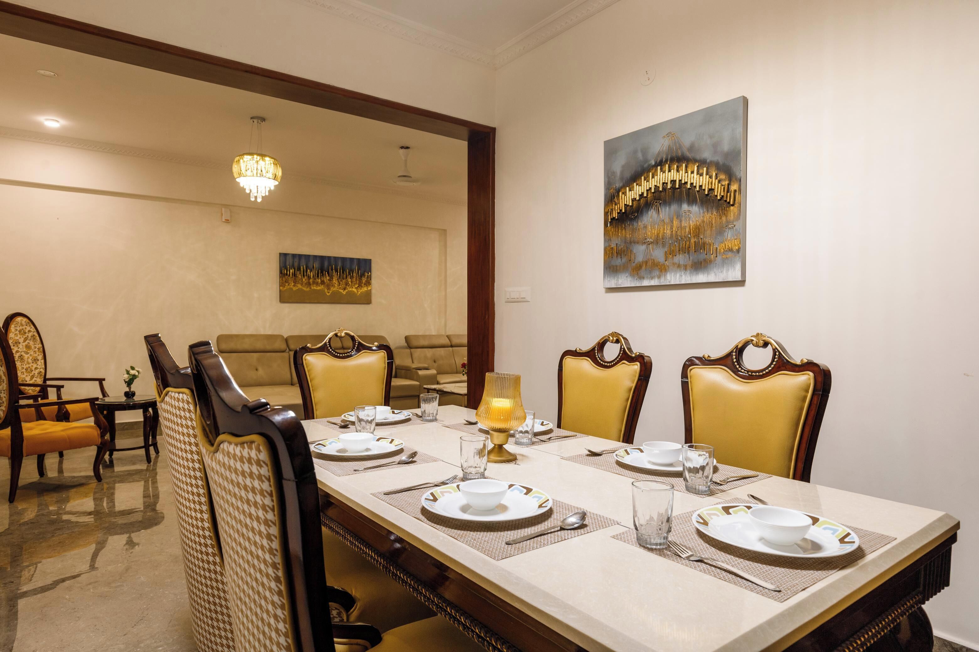 A dining area with a long table set for six, surrounded by upholstered chairs with a houndstooth pattern.