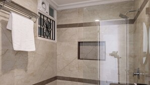 A modern bathroom with a glass-enclosed shower, a white sink, and a towel rack. - Emerald Apartments by Red Olive (Bengaluru)