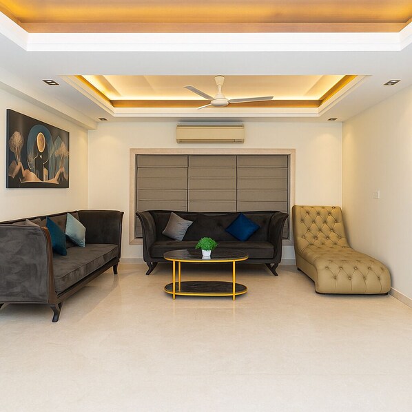 A modern living room with a sofa, armchair, and coffee table. - Elan Royale by Jadecaps (Kolkata)