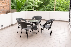 A small outdoor patio with a round table and four chairs. - Elan Royale by Jadecaps (Kolkata)