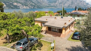 A building with a flat roof, a paved driveway, and a sign indicating an official office. - Villaggio Turistico Priori Malcesine (Malcesine)