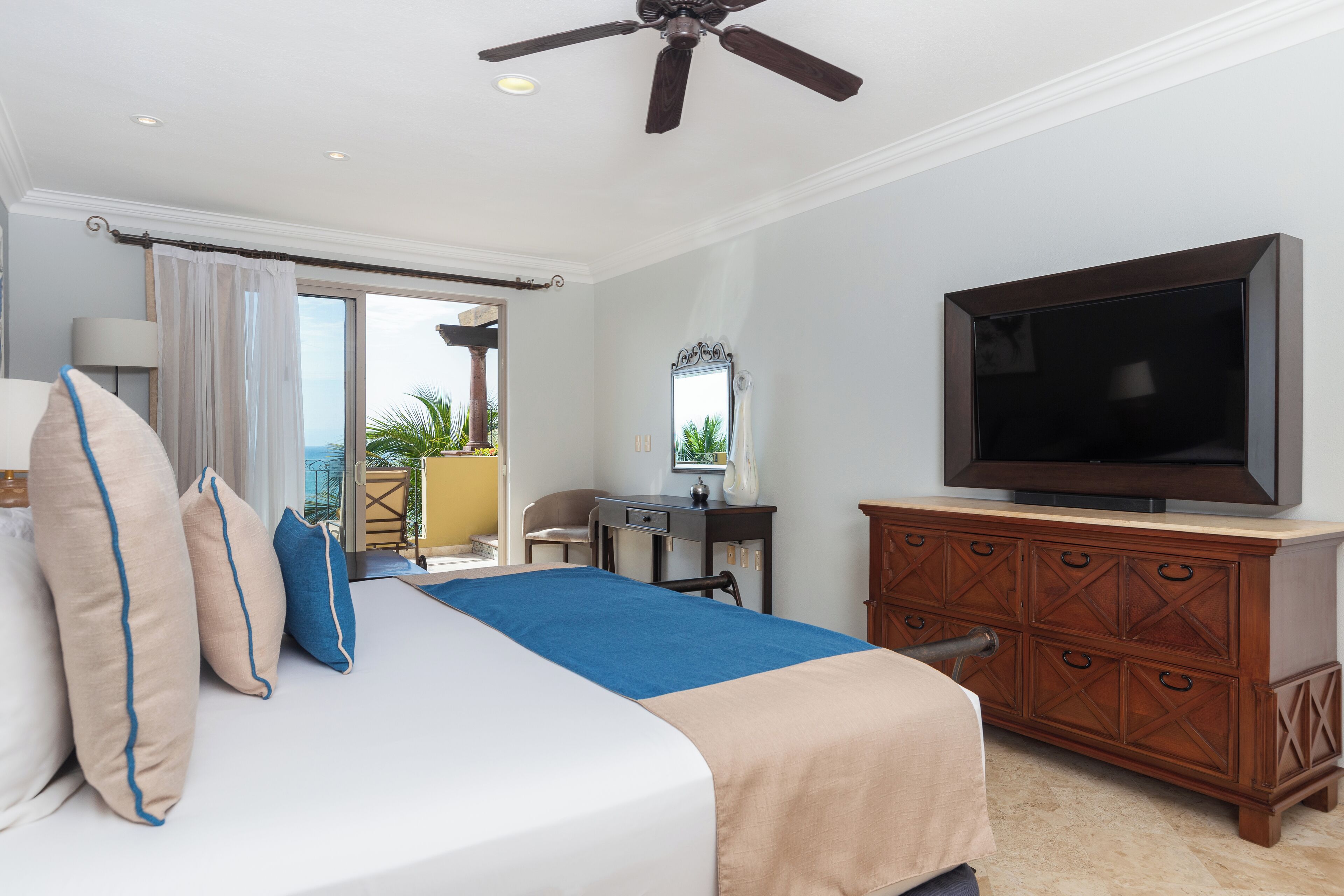 A hotel room with a bed, a dresser, a television, a desk, and a chair.