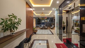 A hotel lobby with a reception desk, seating area, and a chandelier. - KLY Hotel Vung Tau (Ho Chi Minh City)