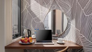 A wooden desk with a laptop, a cup, a plate with apples, and a kettle. - KLY Hotel Vung Tau (Ho Chi Minh City)