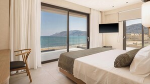 A hotel room with a bed, a chair, a TV, and a large window offering a view of the sea and mountains. - Onora Villa, Steps from the Sea by etouri (Chania)