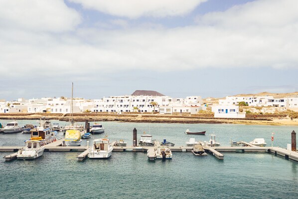 Marina costeira com edifícios brancos e barcos atracados.