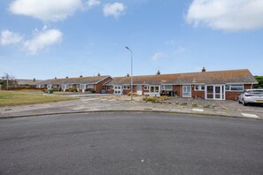 A row of terraced houses with a paved driveway and a street lamp. - Amazing Beachside 2Bd Family Home With Garden (Margate)