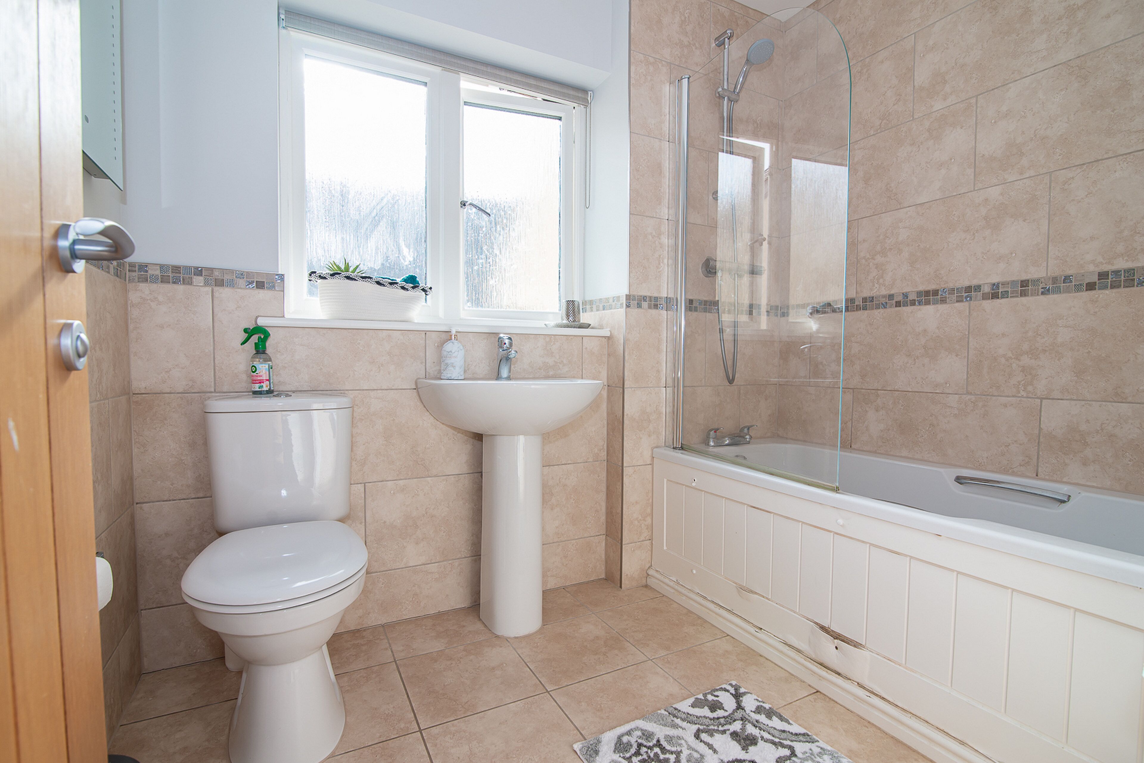 A bathroom with a toilet, sink, and bathtub.
