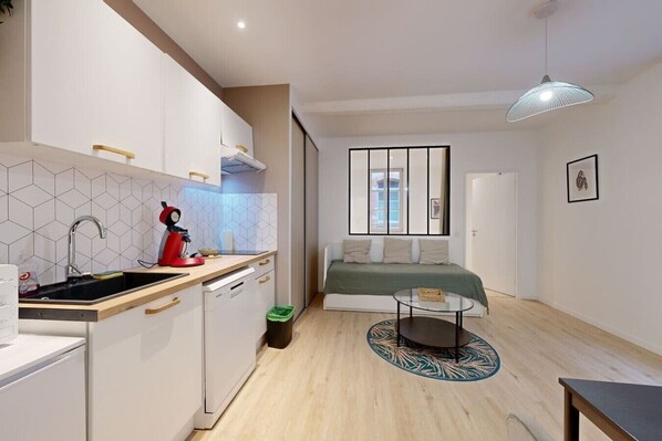 Um espaço compacto com cozinha compacta, área de refeições e cama.