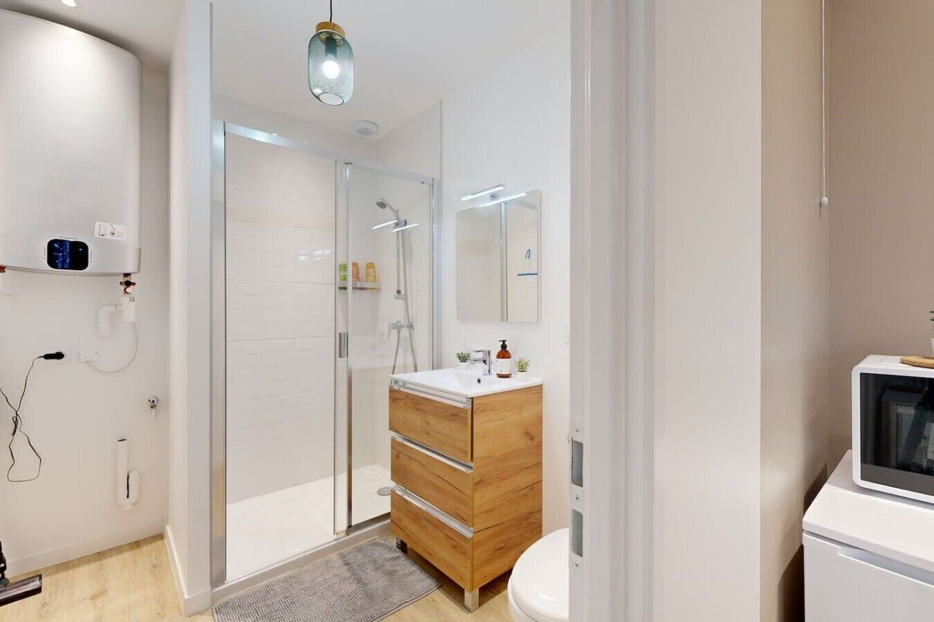 Une salle de bain moderne avec une douche à parois de verre, un meuble-lavabo en bois et des toilettes blanches.