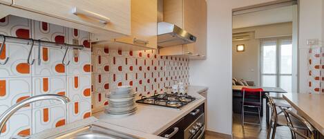 A modern kitchen with a stainless steel sink, a gas stove, and wooden cabinets.