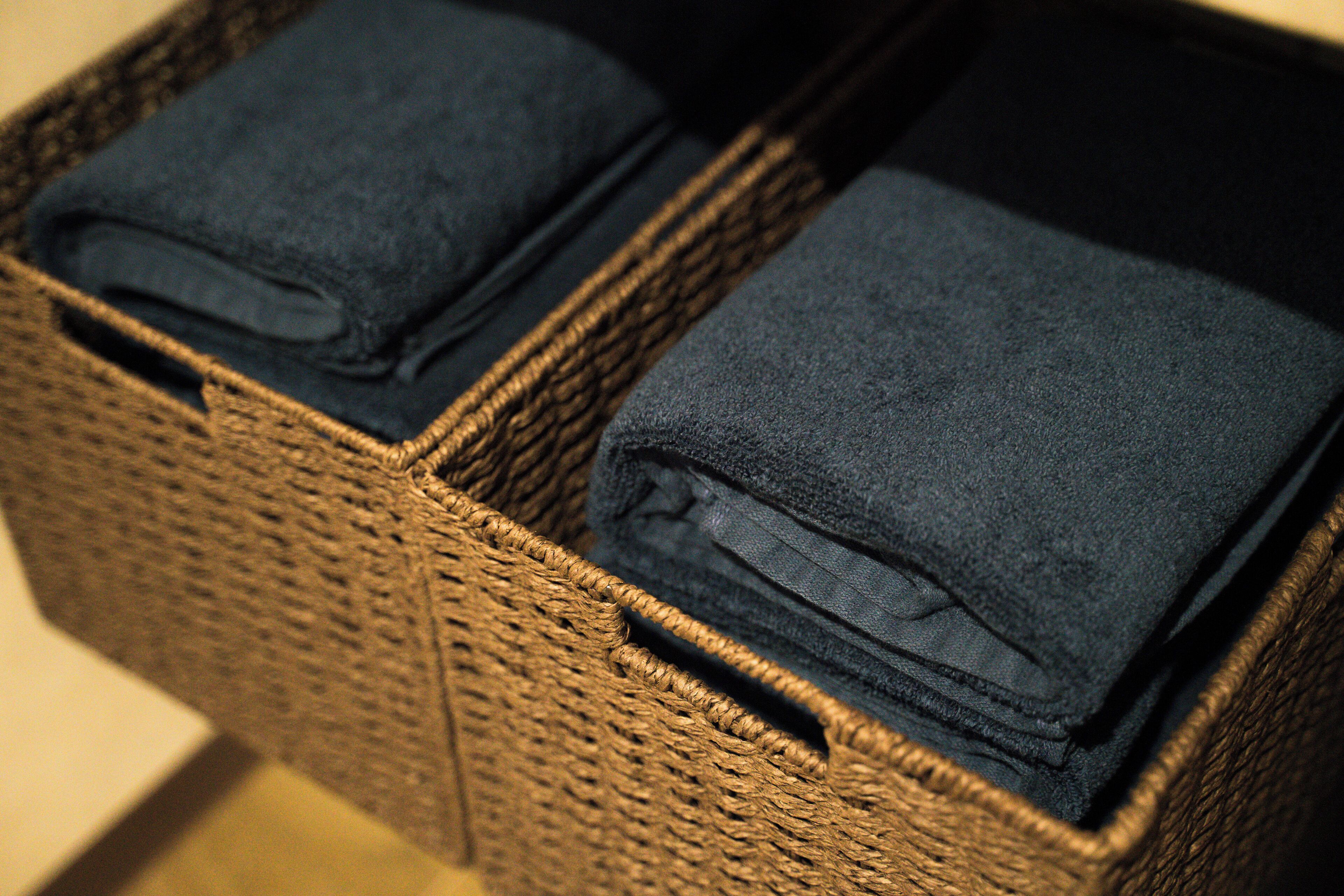 Una cesta de mimbre con jeans azul oscuro doblados.
