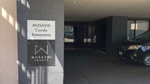 A parking area with a sign for Musashi Condo Kanazawa. - MUSASHI Condo Kanazawa (Kanazawa)