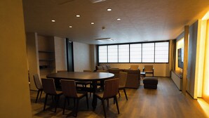 A spacious meeting room with a large round table, several chairs, and a view through large windows. - MUSASHI Condo Kanazawa (Kanazawa)