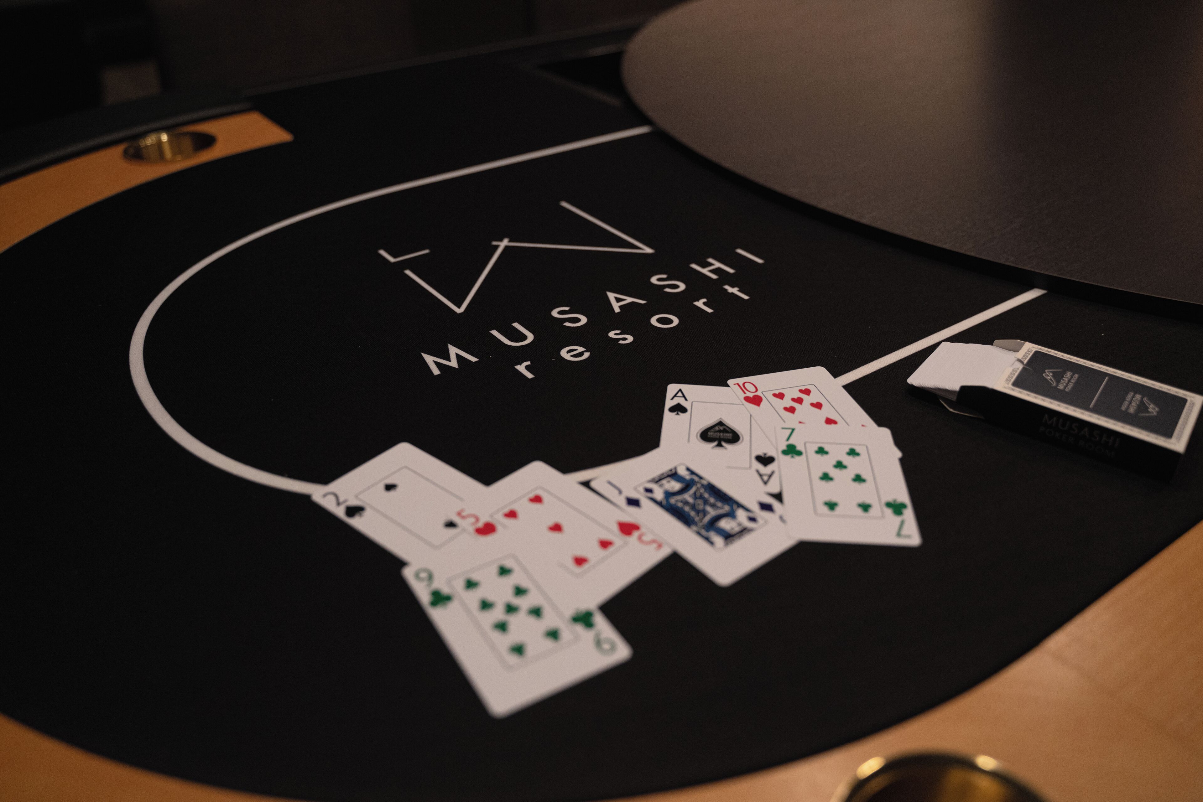 Ein Blackjack-Tisch in einem Casino mit ausgelegten Karten und einem Mobiltelefon darauf.