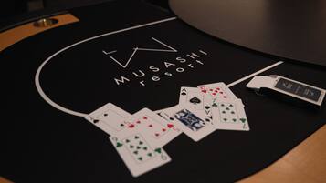 Ein Blackjack-Tisch in einem Casino mit ausgelegten Karten und einem Mobiltelefon darauf.