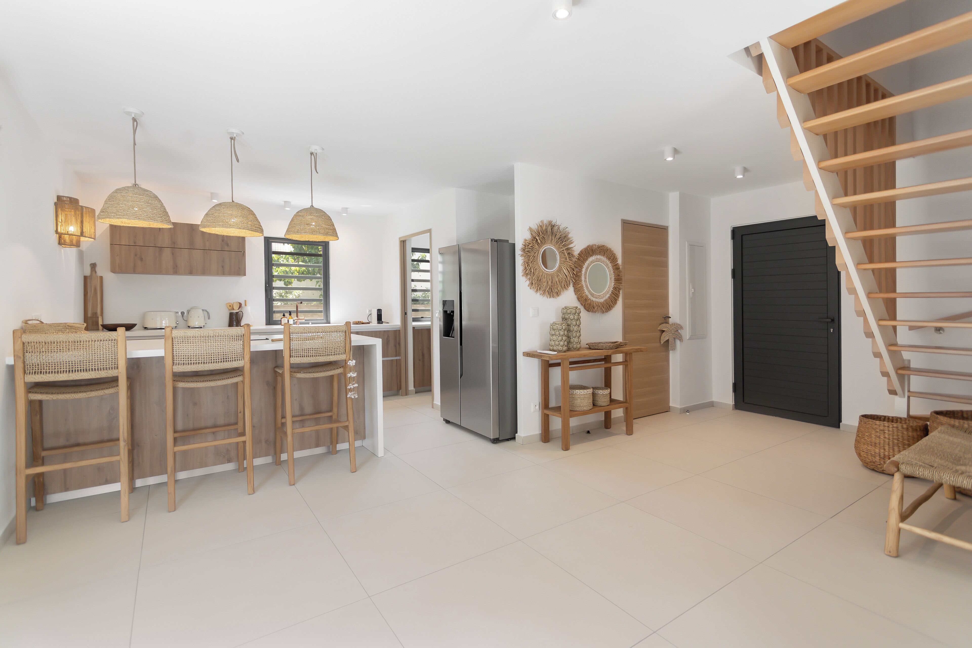 A modern kitchen with wooden chairs, a dining table, and a built-in refrigerator.