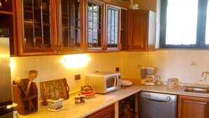 A kitchen with wooden cabinets, a microwave, a coffee maker, and a dishwasher.