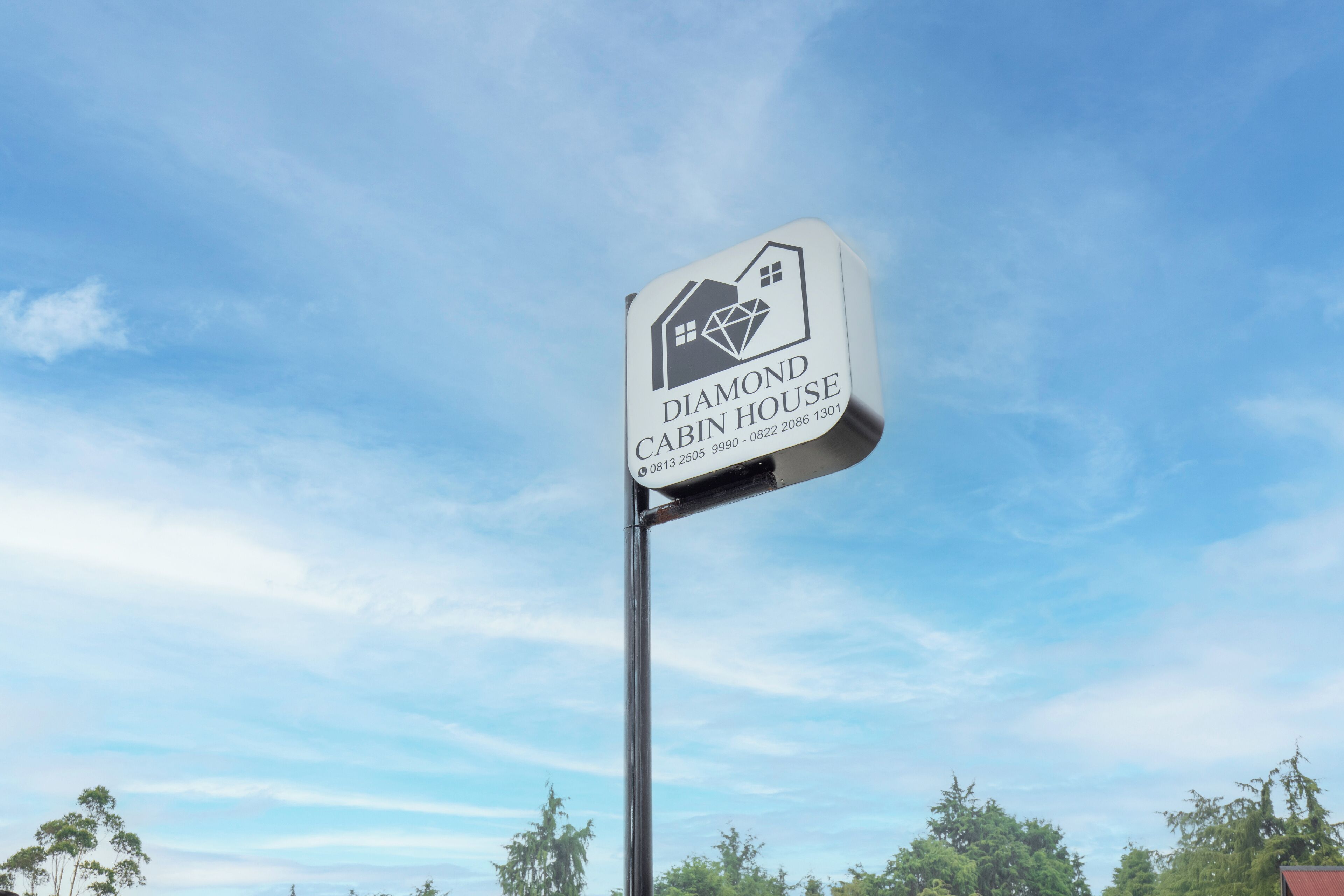 A sign for the Diamond Cabin House with a contact number.