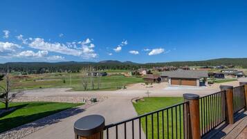 A residential area with a clear view of a large open space, possibly a park or golf course, with houses in the background.