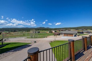 A residential area with a clear view of a large open space, possibly a park or golf course, with houses in the background. - Golf Course, Sleeps 12, Garage (Sturgis)