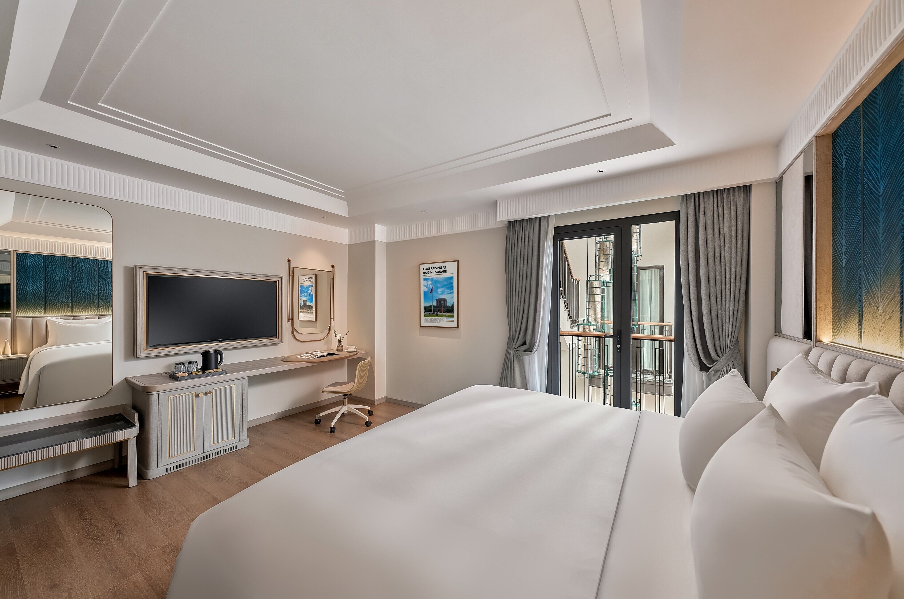 Una habitación de hotel moderna con una cama grande, un escritorio con televisor de pantalla plana, una zona de estar y un balcón con vistas a la ciudad.