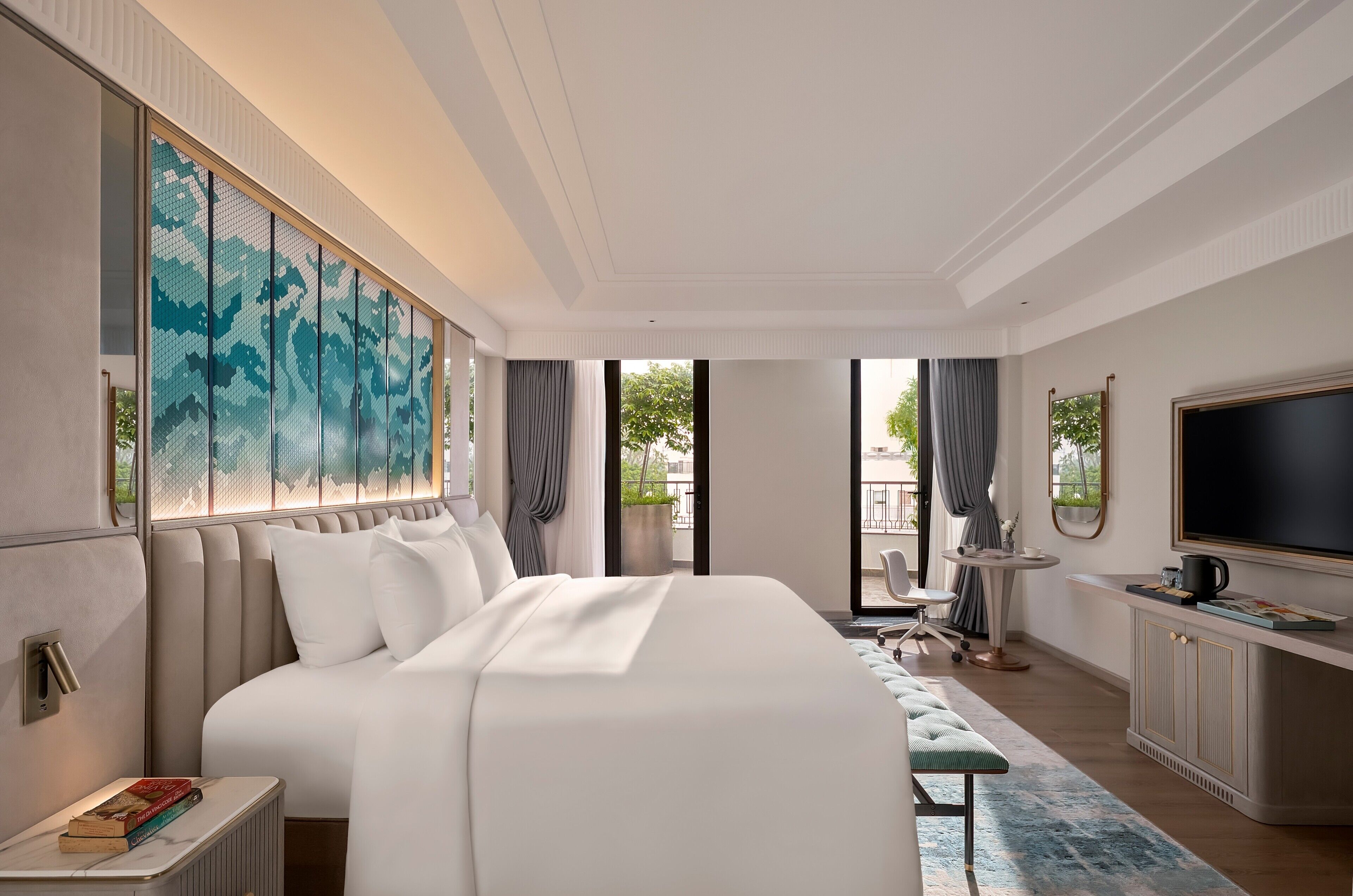 A modern hotel room with a large bed, a television, a small table, and a view of the outdoors.
