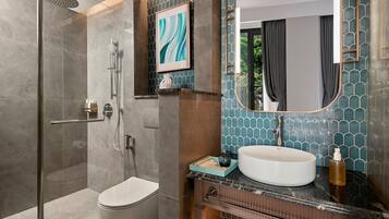 Een moderne badkamer met een douchecabine van glas, een wit toilet, een wastafelmeubel met een grote spiegel en een wastafel.