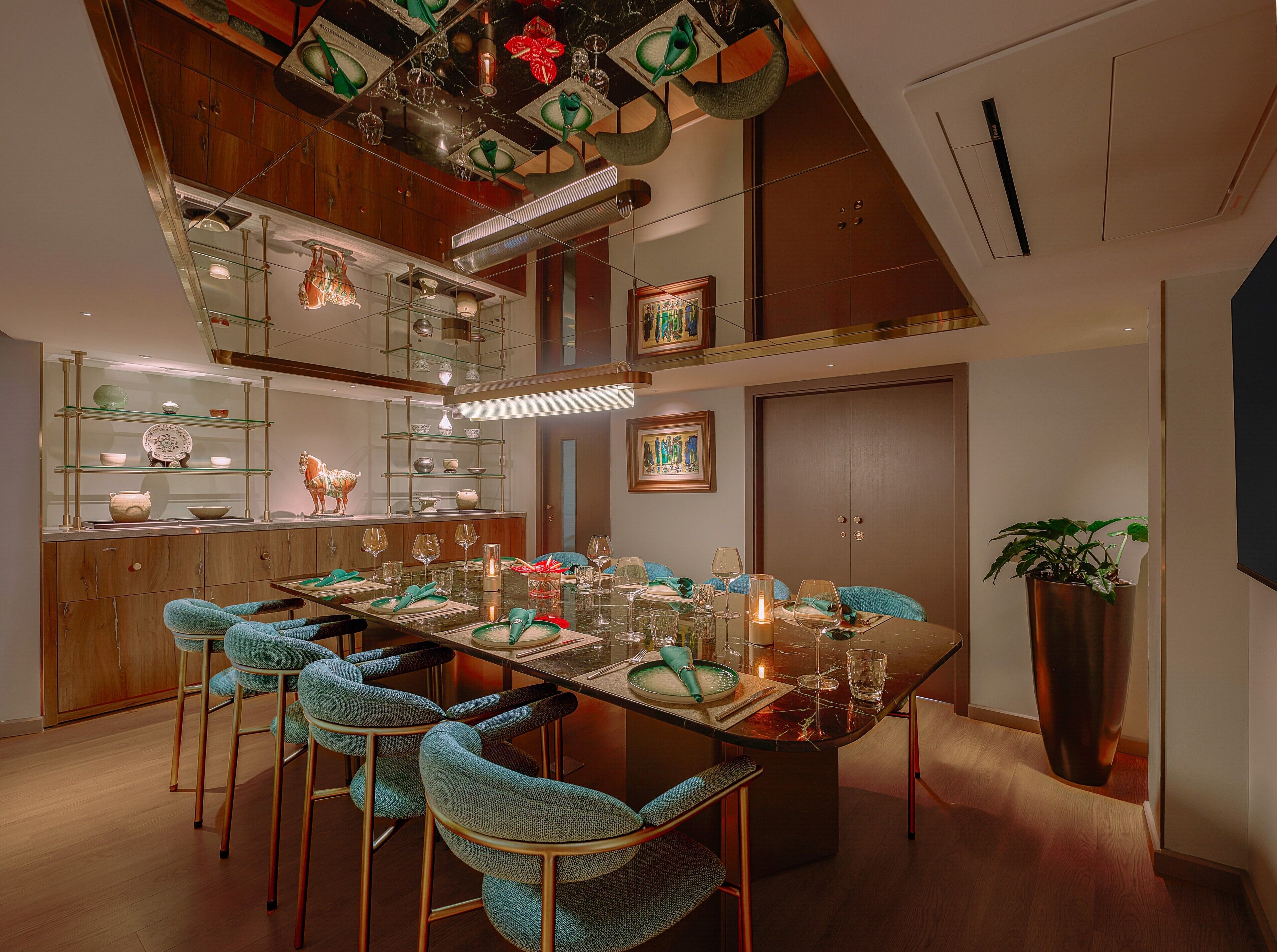 Un espace repas moderne avec une table en verre, des chaises de couleur turquoise et un plafond en bois.