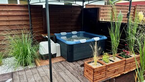 A hot tub surrounded by wooden planters with various plants. - Modern vacation bungalow in the Neuhof forest settlement on the Großer Wünsdorfer See lake (Zossen (Neuhof))